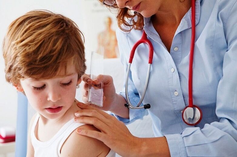 médico examina a un neno con papiloma no corpo